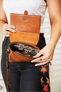 Close-up of a wide strap crossbody bag with a spacious interior and colorful lining.