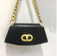 Chic Élan underarm bag in black with a gold chain, featuring a sleek silhouette and premium materials.
