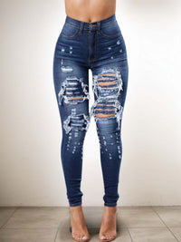 Ripped high waist jeans for women with trendy distressed details, perfect for chic streetwear style.