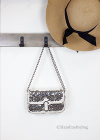 Marc Jacobs The Mini J Marc sequined shoulder bag displayed with a hat, showcasing the mini sequined shoulder bag design.
