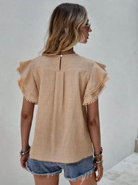 Back view of Ruffle Cap Sleeve Blouse for Women in beige, styled with denim shorts for a casual look.