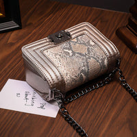 Bertha shoulder bag in python texture vegan leather with chain detail and unique closure. Perfect vegan leather shoulder bag.