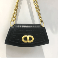 Chic Élan underarm bag featuring a black leather texture and gold chain strap, showcasing modern elegance.