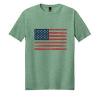 Vintage flag tee shirt on a heathered dusty sage background featuring a distressed American flag design.