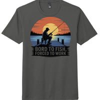 Fishing themed tri-blend tee in charcoal with graphic: 'Bord to Fish, Forced to Work' on a serene sunset backdrop.
