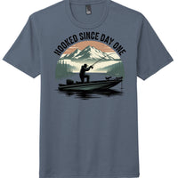 Hooked since day one graphic on navy frost perfect tri blend tee, featuring a fishing scene with mountains and water.